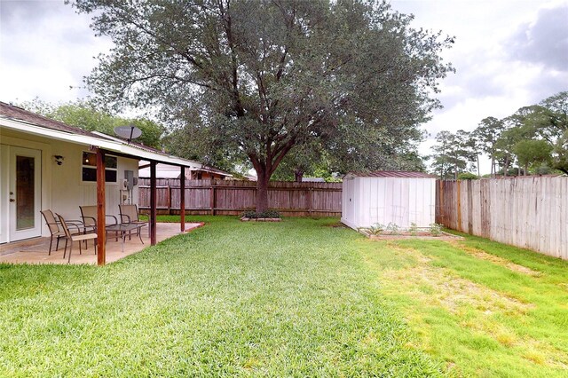 view of yard featuring a fenced backyard, a patio area, a storage shed, and an outbuilding