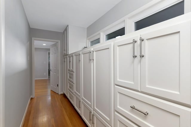 hall featuring recessed lighting, baseboards, and wood finished floors