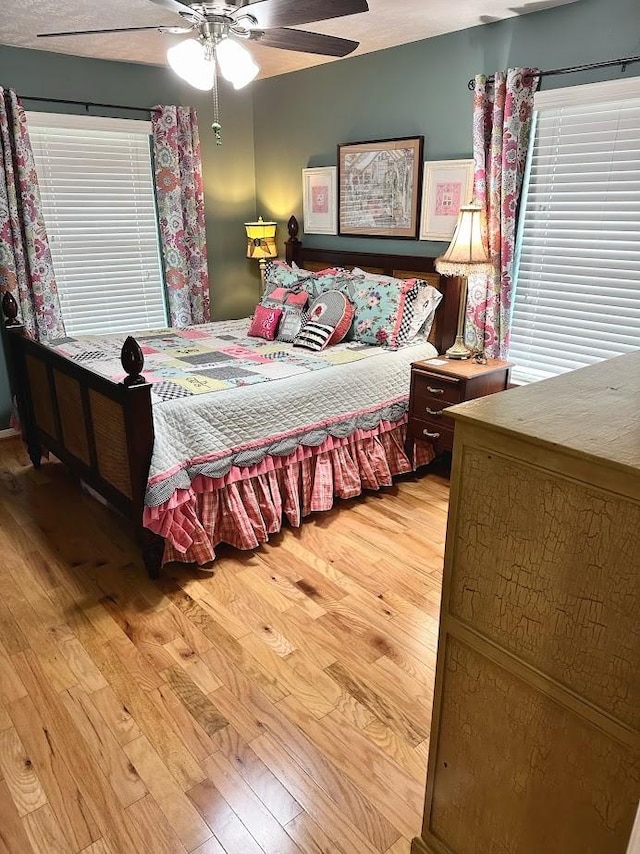bedroom with a ceiling fan and light wood-style flooring