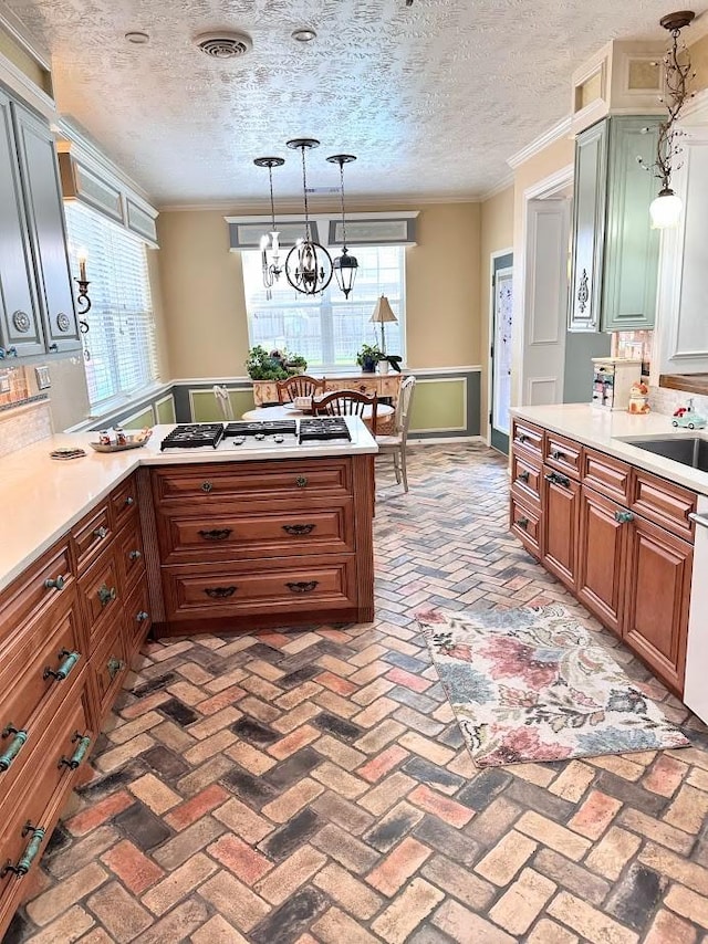 kitchen with light countertops, white gas stovetop, and brick floor