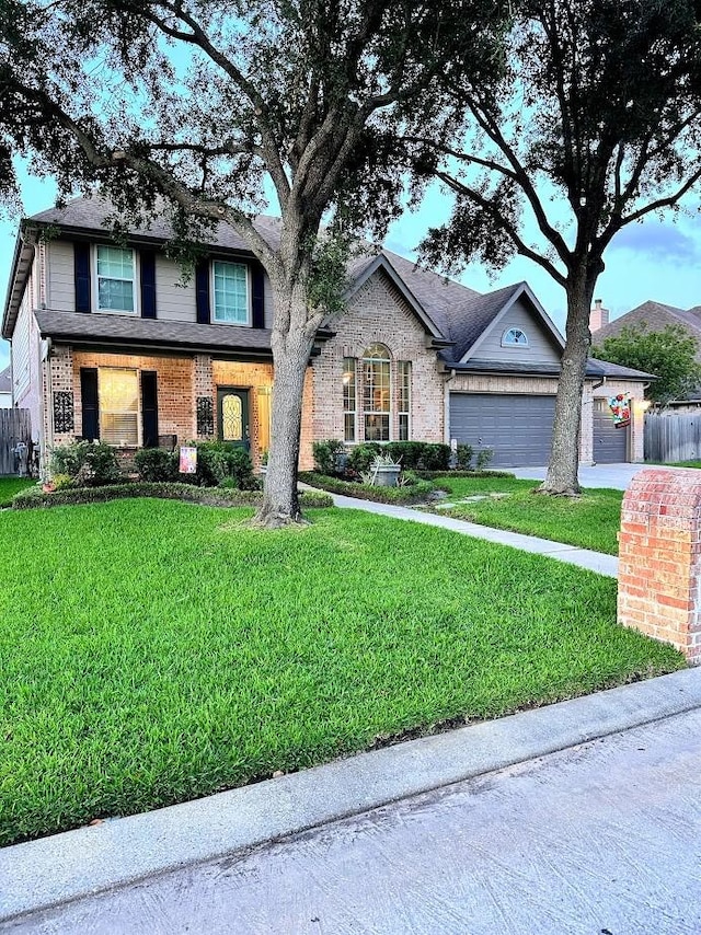 traditional-style home with brick siding, an attached garage, and a front yard