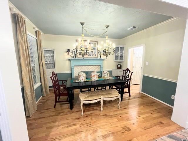 18606 Spring Heather Ct, Spring, TX 77379 - dining space with a chandelier, light wood finished floors, ornamental molding, a textured ceiling, and baseboards
