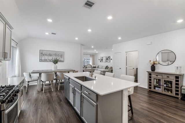 kitchen with gray cabinets, a kitchen island with sink, visible vents, appliances with stainless steel finishes, and a sink