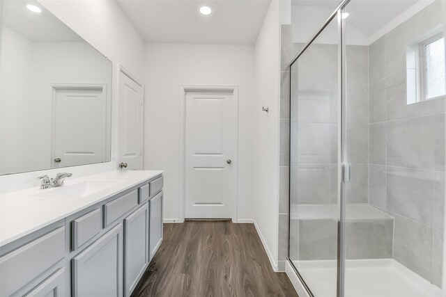 full bath with vanity, a shower stall, recessed lighting, and wood finished floors
