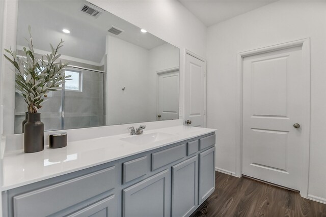 full bath featuring an enclosed shower, visible vents, wood finished floors, and vanity