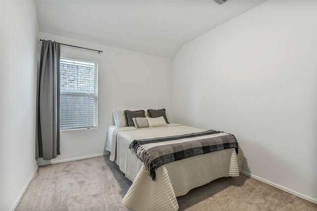 bedroom with visible vents, baseboards, vaulted ceiling, and carpet