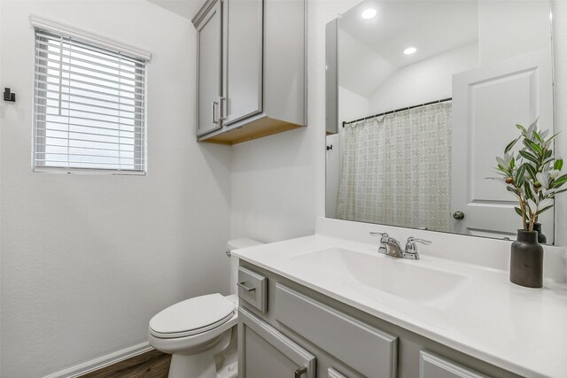 bathroom with wood finished floors, vanity, baseboards, toilet, and recessed lighting