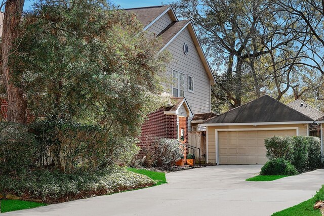 view of side of home featuring concrete driveway and an attached garage