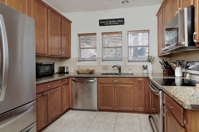 kitchen featuring backsplash, stainless steel appliances, and brown cabinetry