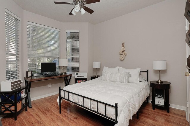bedroom with baseboards, a ceiling fan, and wood finished floors