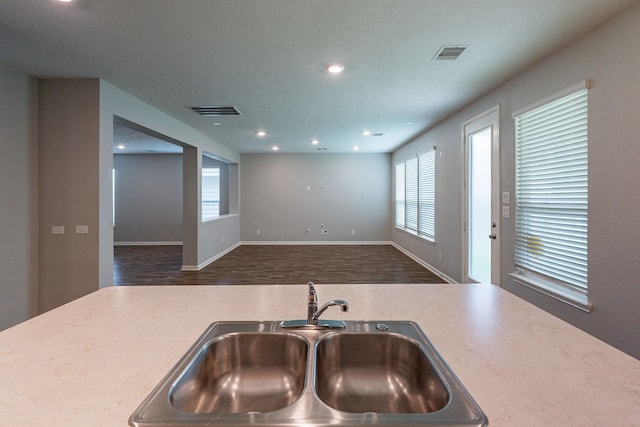 kitchen with a sink, light countertops, wood finished floors, and visible vents