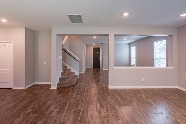 interior space with stairs, recessed lighting, baseboards, dark wood-type flooring, and visible vents