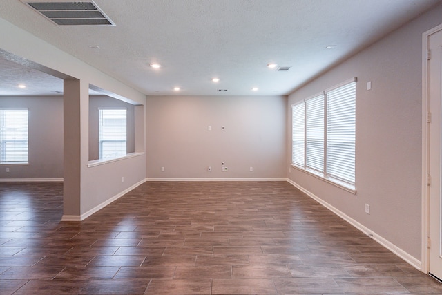 empty room with recessed lighting, wood finish floors, visible vents, and baseboards