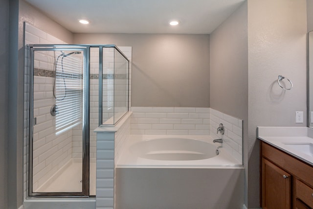 full bath with vanity, a bath, and a stall shower