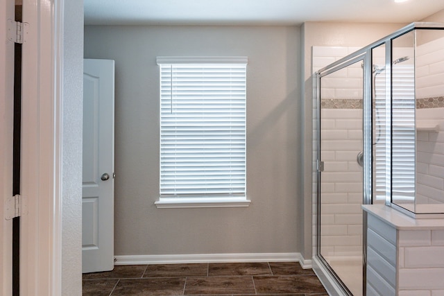 full bath featuring baseboards and a shower stall