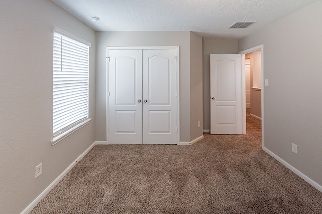 unfurnished bedroom with visible vents, carpet floors, a closet, and multiple windows