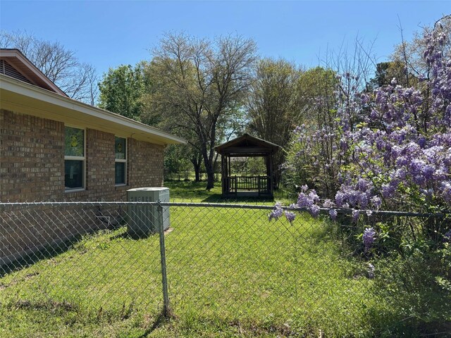 view of yard with central air condition unit, fence, and a gazebo