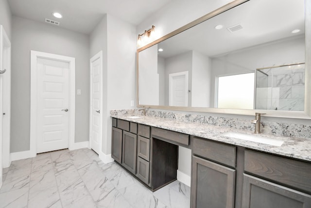 bathroom featuring a sink, a shower stall, double vanity, and marble finish floor