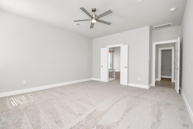 unfurnished bedroom featuring visible vents, carpet flooring, baseboards, and ensuite bath