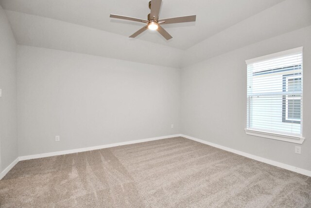 carpeted spare room featuring a ceiling fan, baseboards, and lofted ceiling
