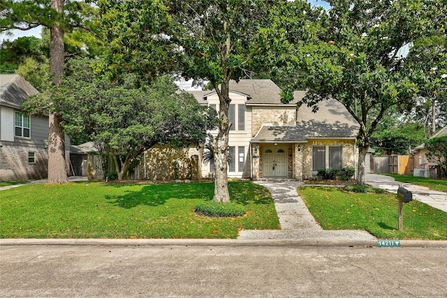 14211 Lakewood Forest Dr, Houston, TX 77070 - view of front of property with a shingled roof, fence, stone siding, and a front yard