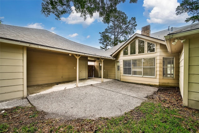 14211 Lakewood Forest Dr, Houston, TX 77070 - rear view of house with a shingled roof, a chimney, and a patio area