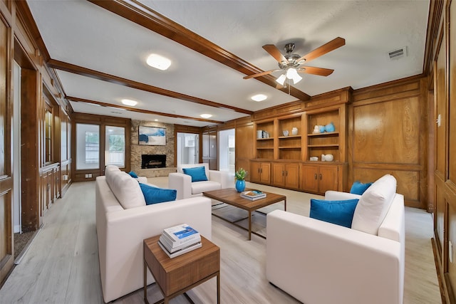 14211 Lakewood Forest Dr, Houston, TX 77070 - living room featuring beam ceiling, light wood finished floors, a fireplace, a ceiling fan, and visible vents