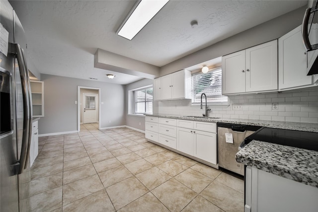 14211 Lakewood Forest Dr, Houston, TX 77070 - kitchen with tasteful backsplash, light stone countertops, a sink, stainless steel appliances, and white cabinetry