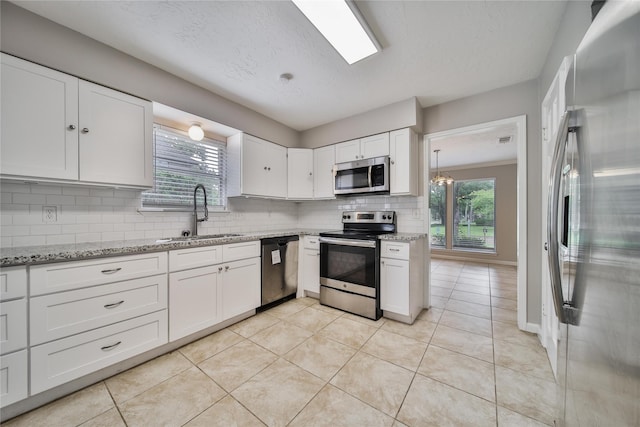 14211 Lakewood Forest Dr, Houston, TX 77070 - kitchen with a sink, appliances with stainless steel finishes, decorative backsplash, and white cabinetry
