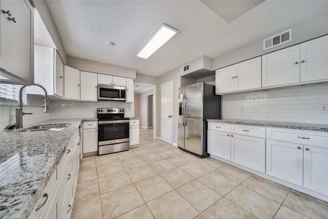 14211 Lakewood Forest Dr, Houston, TX 77070 - kitchen featuring visible vents, a sink, backsplash, and stainless steel appliances
