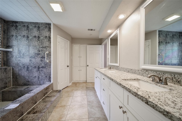 14211 Lakewood Forest Dr, Houston, TX 77070 - bathroom with visible vents, a sink, double vanity, and tiled shower