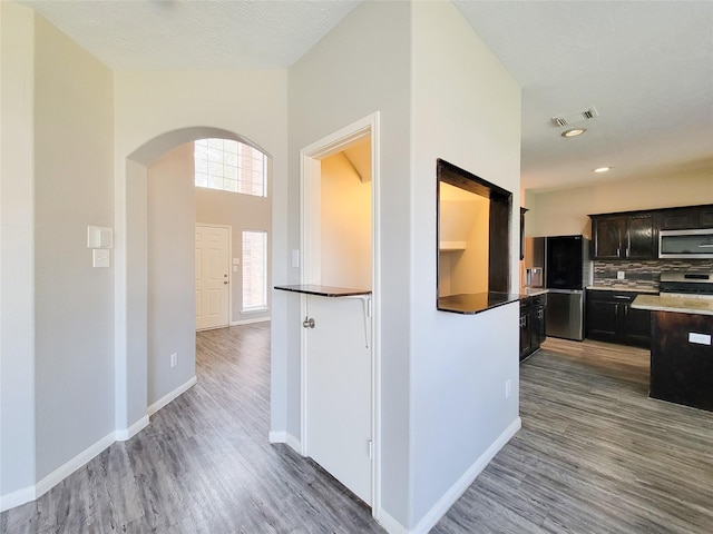3111 Silverstag Trail Ln, Houston, TX 77073 - kitchen featuring visible vents, wood finished floors, baseboards, arched walkways, and stainless steel appliances