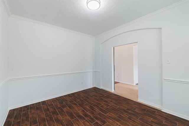 empty room featuring baseboards, ornamental molding, and wood finish floors