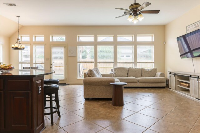 living room with ceiling fan, visible vents, a wealth of natural light, and light tile patterned floors