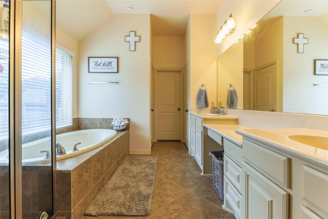 bathroom featuring a sink, tile patterned flooring, double vanity, lofted ceiling, and a garden tub