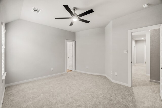 spare room with ceiling fan, light carpet, baseboards, lofted ceiling, and visible vents