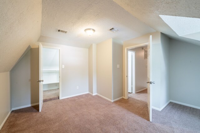 additional living space with carpet floors, visible vents, and vaulted ceiling