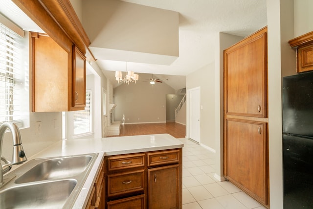 18927 Sandia Pines Dr, Humble, TX 77346 - kitchen with a sink, a chandelier, freestanding refrigerator, a peninsula, and light tile patterned floors