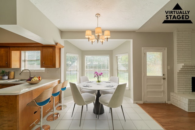 18927 Sandia Pines Dr, Humble, TX 77346 - dining area with a chandelier, baseboards, a textured ceiling, and light tile patterned flooring