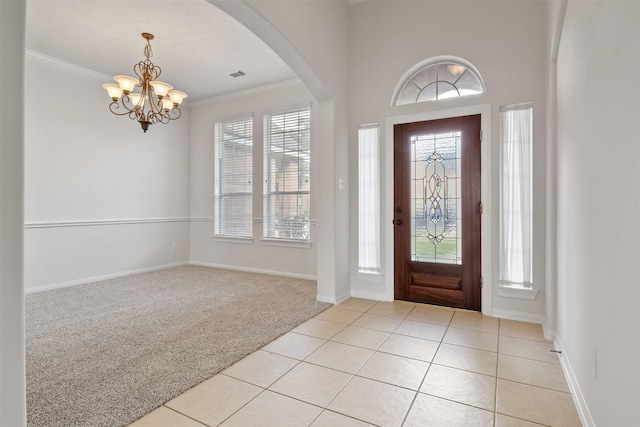 2126 Fortuna Bella Dr, Pearland, TX 77581 - entryway with ornamental molding, baseboards, light colored carpet, light tile patterned floors, and a notable chandelier