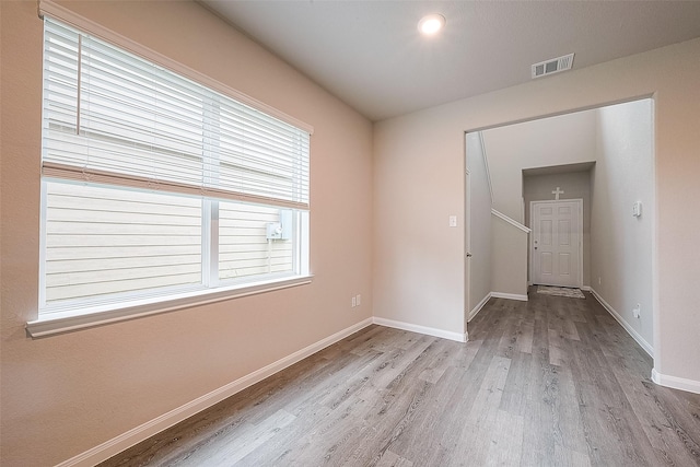 unfurnished room with visible vents, baseboards, and wood finished floors