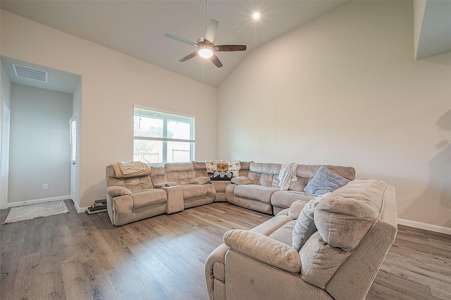 living room featuring visible vents, wood finished floors, baseboards, ceiling fan, and high vaulted ceiling