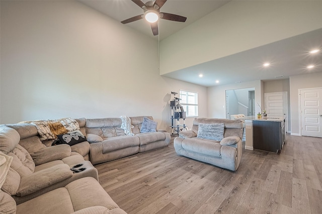 living room with light wood-type flooring, a ceiling fan, and recessed lighting