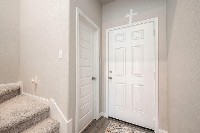 entryway featuring a textured wall, dark wood finished floors, and baseboards