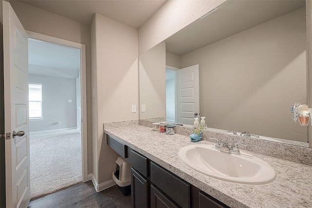 bathroom featuring vanity, baseboards, and wood finished floors