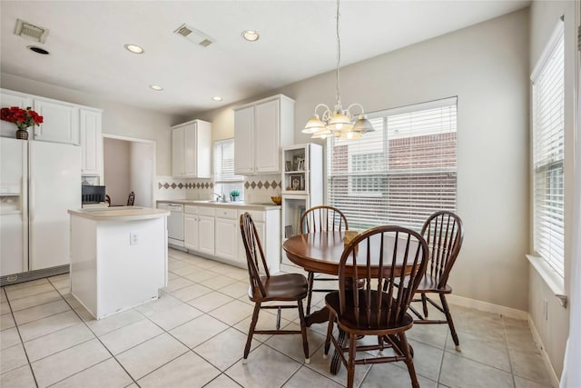 dining area with visible vents, a wealth of natural light, and an inviting chandelier