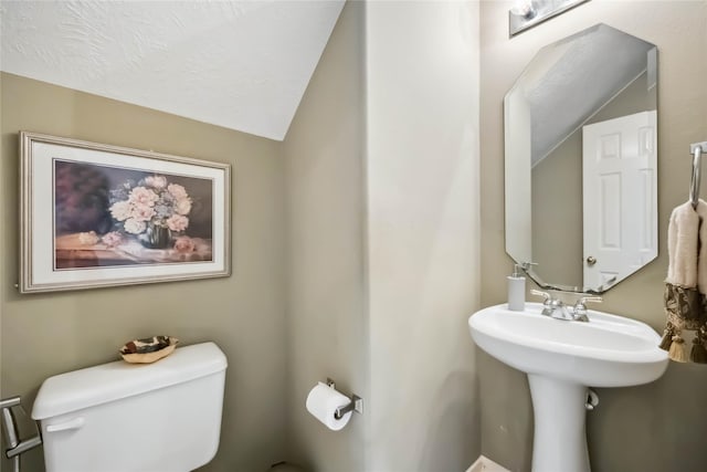 half bathroom featuring toilet and lofted ceiling