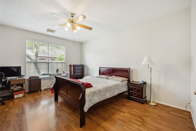bedroom with baseboards, a ceiling fan, light wood-type flooring, and visible vents