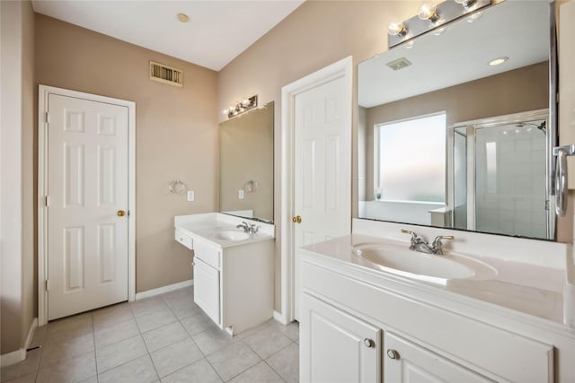 bathroom featuring a sink, tile patterned flooring, a shower stall, and visible vents