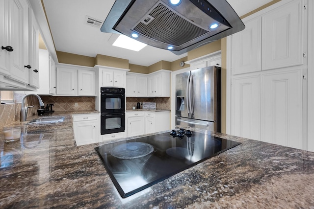 kitchen featuring white cabinets, extractor fan, a sink, and black appliances